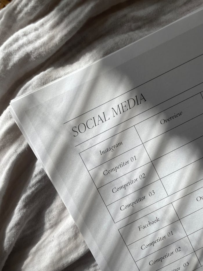 hero-img-01 Closeup of a social media plan on paper with fabric texture and dramatic shadows.